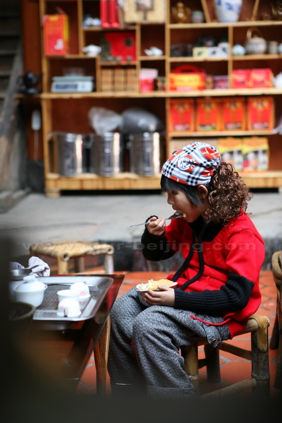 A Tulou girl is eating her meal