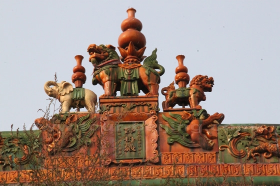 A group of elephants and dragon heads atop the roof ridge of the Hall of Fertility Goddess
