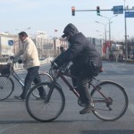 A heavily clad rider is riding on a street.