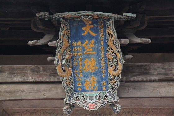 A plaque intricately carved with four Chinese characters hanging over the entrance to the Hall of Heavenly Kings.