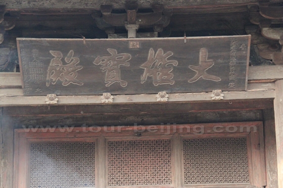 A plaque written with four bold Chinese characters of the Precious Hall of Mahavira hanging over the entrance to the Hall.
