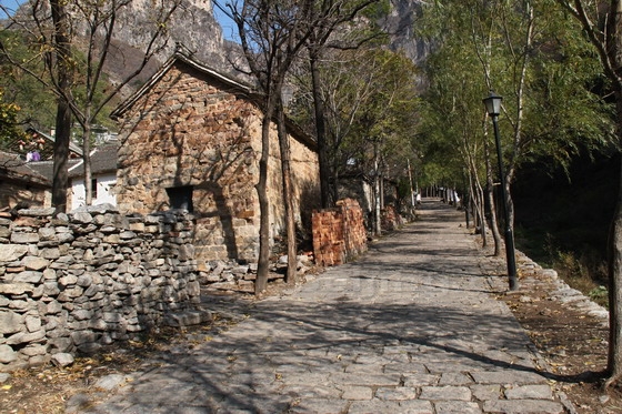 A stone paved road leading up to the back of the village