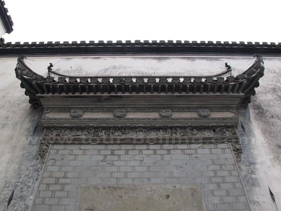 Close view of the decorated upper eves above the entrance gate