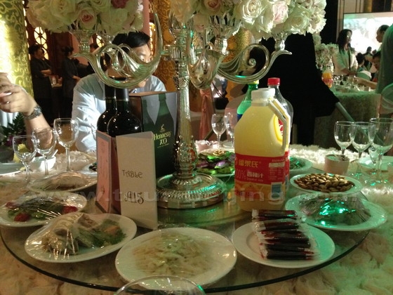 Each table is decorated with a flower stand and piled with drinks, wines and appetizers and cold dishes