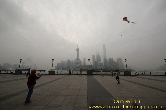 Flying a kite with the backdrop of the Pudong Skyline.