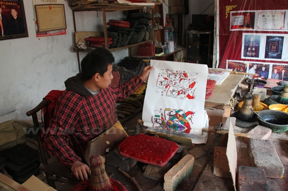 He checks the red color added to the rice paper