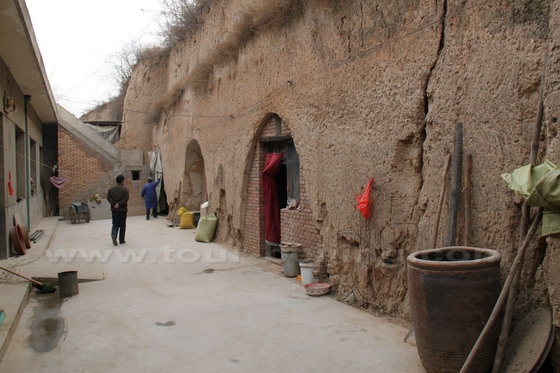 His family has a big brick house linked to the yaodongs carved from a vertical hill.