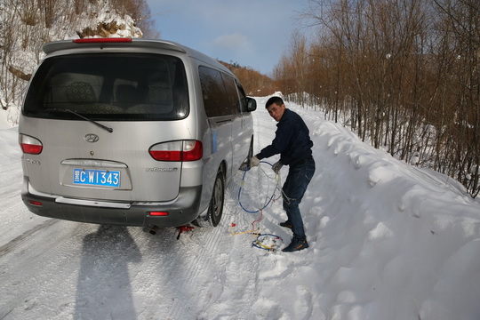 Mr.Jia has to put snow chains on his van