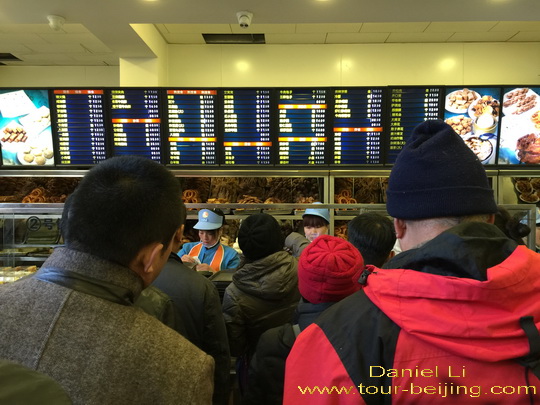 People line up and wait in turn to order their snacks