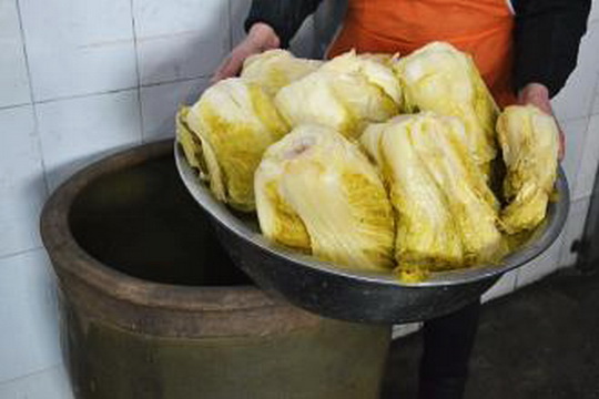 Take a pickled Chinese cabbage preserved in a big ceramic vat.