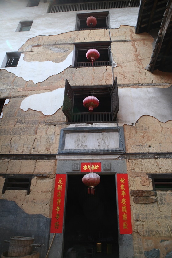 Red lanterns are hung along the Tulou