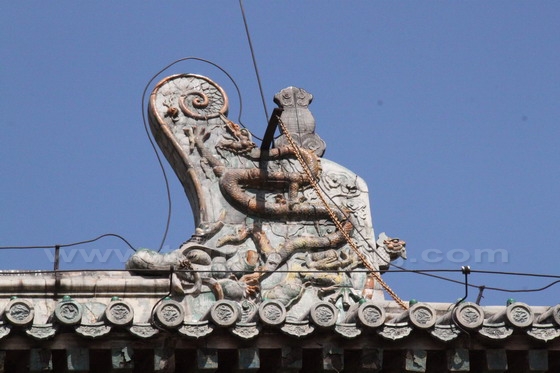 The carved dragon on the mural above the roof.