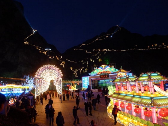 The lit colorful lanterns with the backdrop of the lit Grea Wall