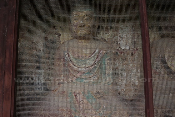 The statues are seen through the mesh grills.