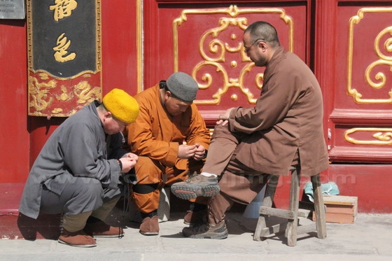 Three - see through life - living monks at leisure time in front of the Mahavira Hall