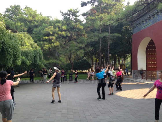 To the west of the Heavenly West Gate people are dancing for morning exercises