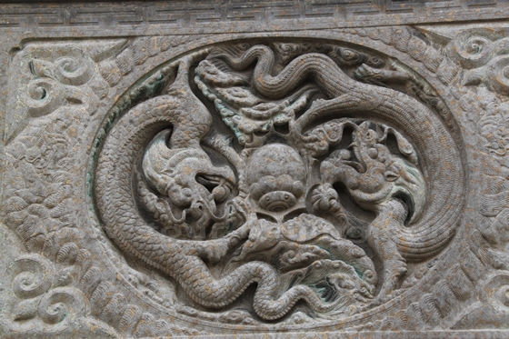 a large stone carving of two dragons playing one spider