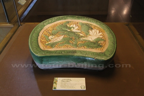 A bean-shaped pillow with a design of ducks and lotus