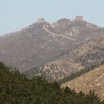 two forts high on the top of the mountains planted with pine trees