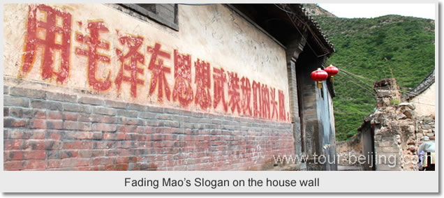 Fading Mao's Slogan on the house wall