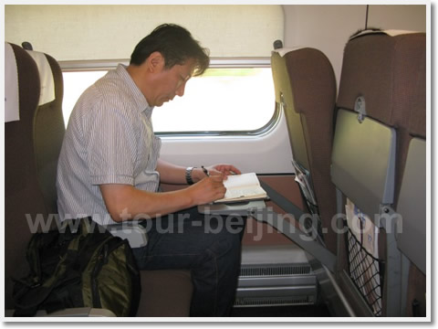 Inside an airplane or a train? A nice tray table and reclining seat