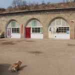 A stone cave dwelling coutyard with a dog gate keeper
