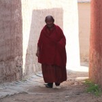 Here comes a smiling monk walking from his living quarters
