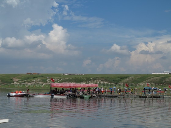 People are boarding pontoon boats seating 8 persons for crusing on the lake.