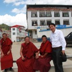 Posed with three monks by the gate to Langmusi Binguan