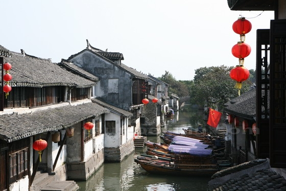 Upturned roof or eaves along with white walls and black tiles reflected on th river.
