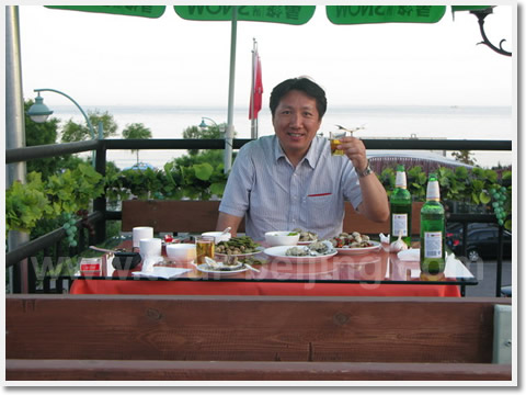 Enjoying seafood on the second floor of the seaside restaurant.