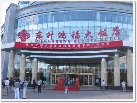 The banner"Warmly Welcome to The International Tourism Festival of Xinjiang" is hung above the entrance to Dongsheng Hongfu Hotel