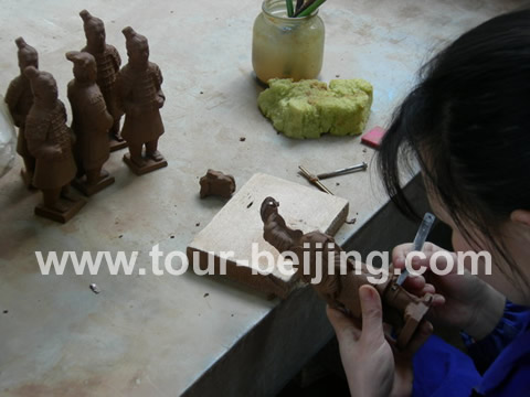 A worker is giving a final touch to a new terra-cotta army soldier.